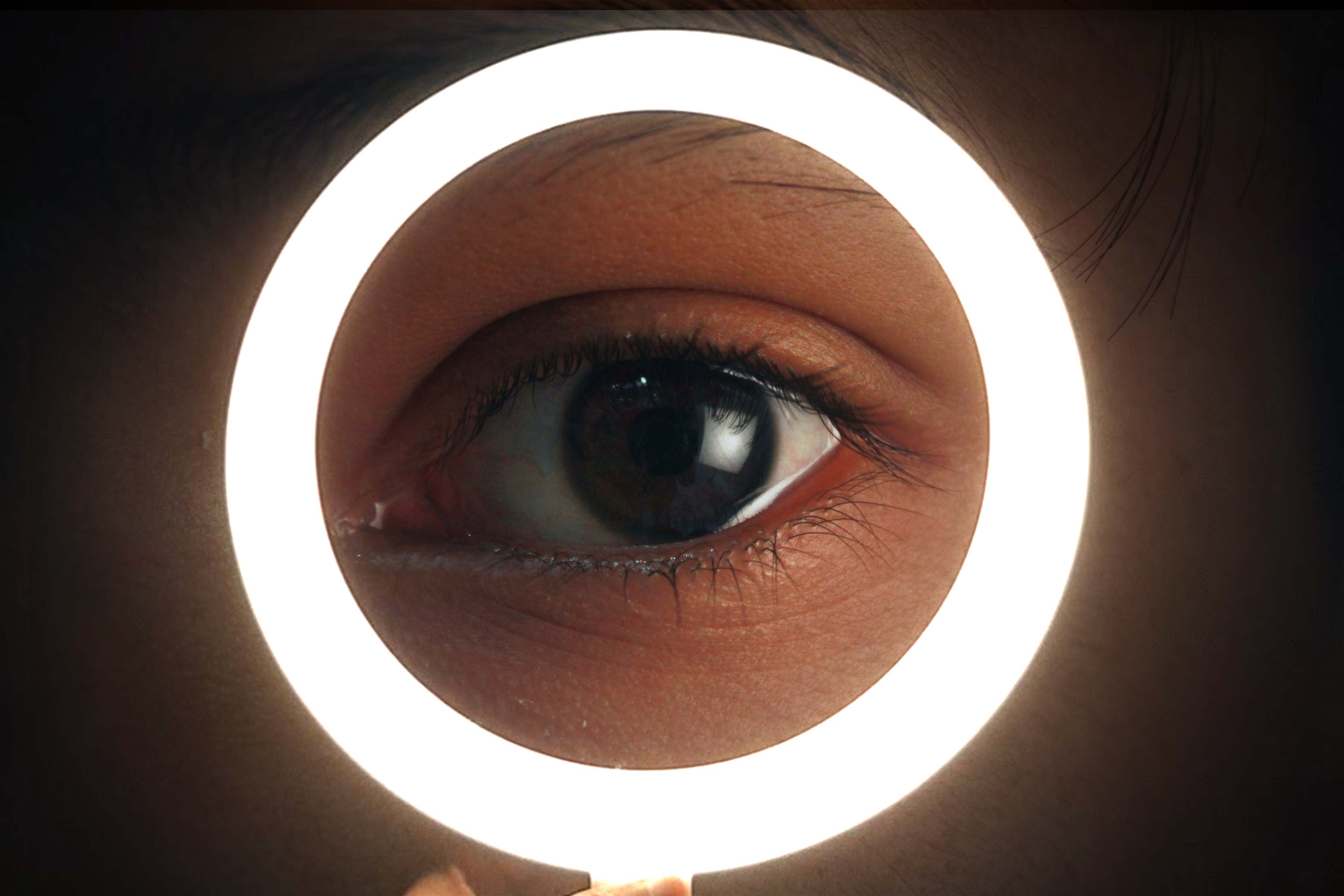 A person's eye, framed by a Photoshopped ring light